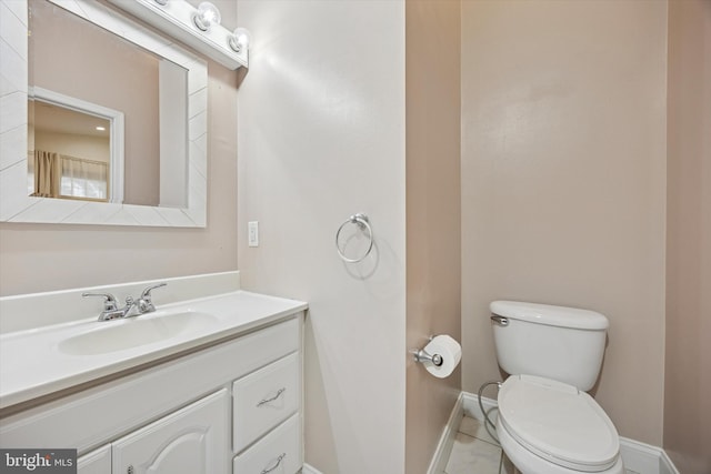 bathroom featuring tile patterned floors, toilet, vanity, and baseboards