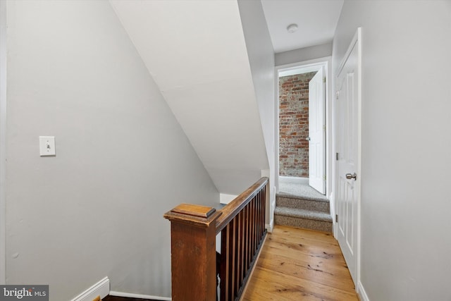 hallway featuring baseboards and light wood finished floors