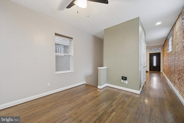 spare room featuring ceiling fan, baseboards, and wood finished floors