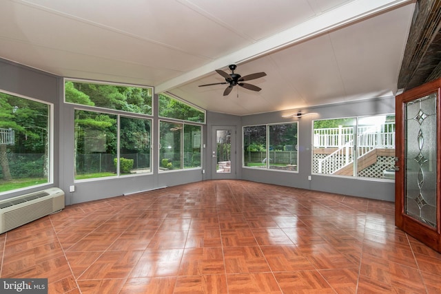 unfurnished sunroom with lofted ceiling with beams, ceiling fan, a wall unit AC, and a healthy amount of sunlight