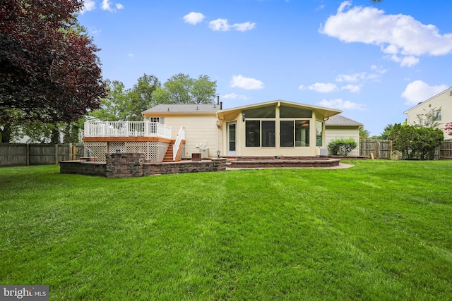 back of house with a sunroom, a fenced backyard, a lawn, and a deck