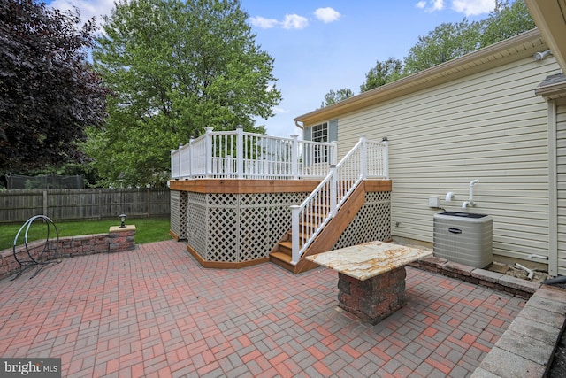 view of patio with a deck, fence, and stairs