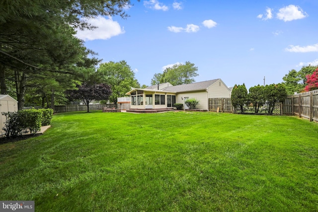 view of yard featuring a fenced backyard and a sunroom