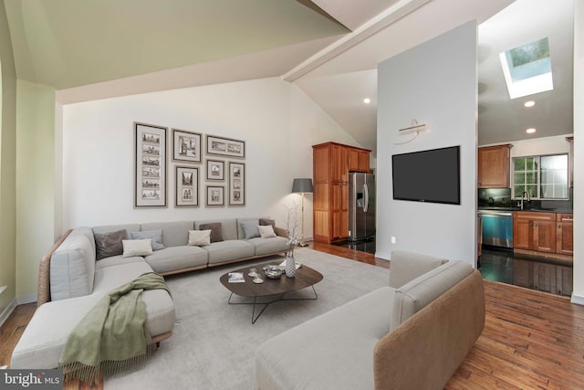 living area with a skylight, high vaulted ceiling, dark wood finished floors, and recessed lighting