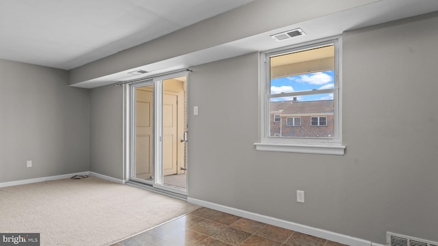 unfurnished room featuring visible vents, carpet flooring, and baseboards