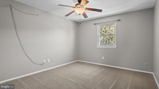 spare room featuring carpet, a ceiling fan, and baseboards