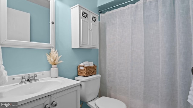 full bath with vanity, a shower with shower curtain, and toilet