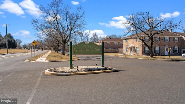 view of road with curbs, a residential view, traffic signs, and sidewalks