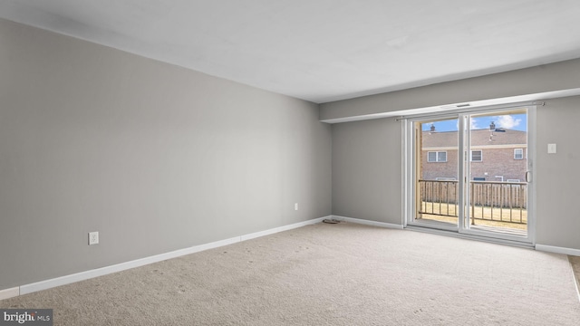 empty room featuring baseboards and carpet