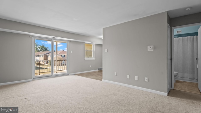 spare room with visible vents, baseboards, and carpet floors