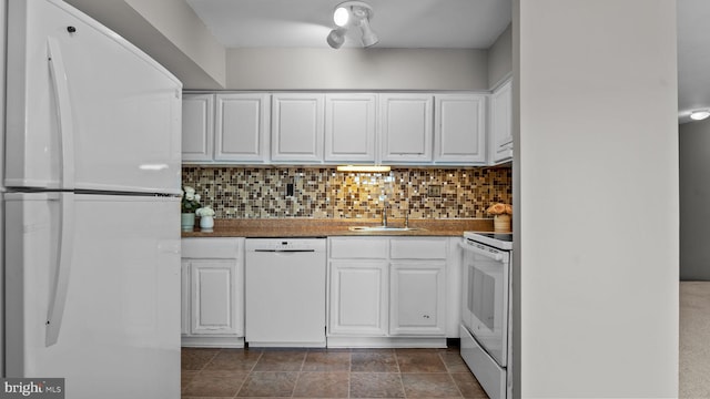 kitchen featuring white appliances, white cabinets, and a sink