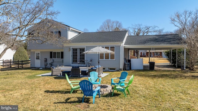 rear view of property featuring french doors, an outdoor fire pit, a yard, and fence