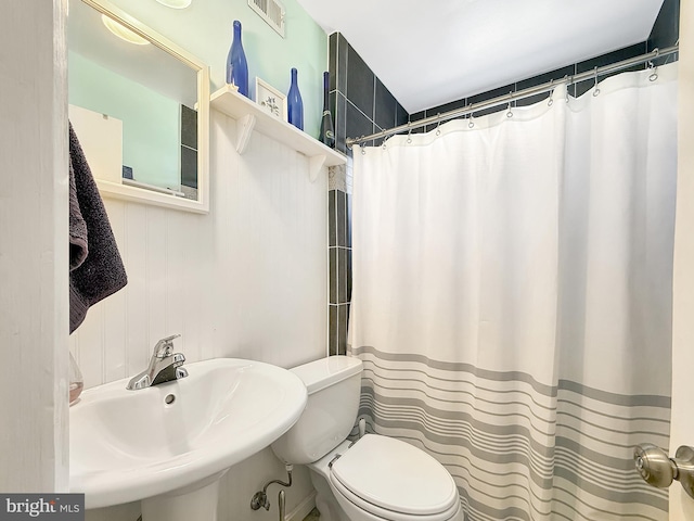 full bathroom with visible vents, toilet, a shower with shower curtain, and a sink