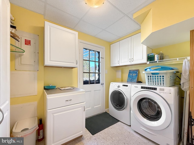 laundry area featuring electric panel, cabinet space, and washer and clothes dryer