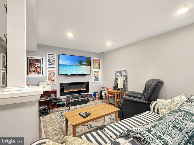 living area with a glass covered fireplace and recessed lighting