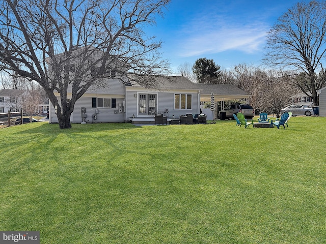 rear view of house with a lawn, a fire pit, roof with shingles, and fence