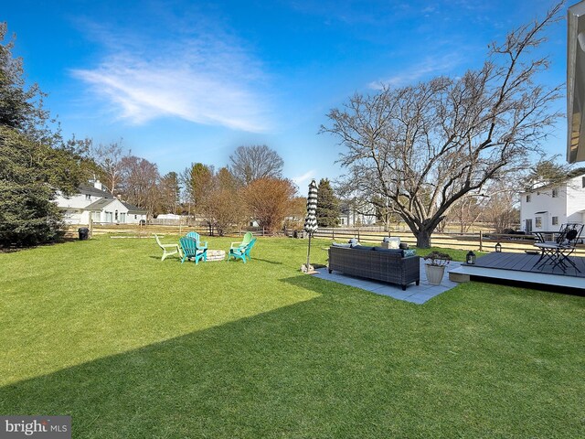 view of yard featuring a wooden deck, outdoor lounge area, and fence