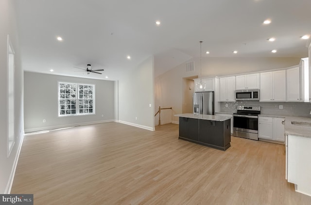 kitchen with visible vents, white cabinets, appliances with stainless steel finishes, open floor plan, and a center island