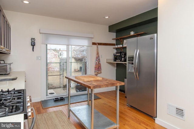 kitchen with visible vents, light wood-style floors, light countertops, appliances with stainless steel finishes, and open shelves