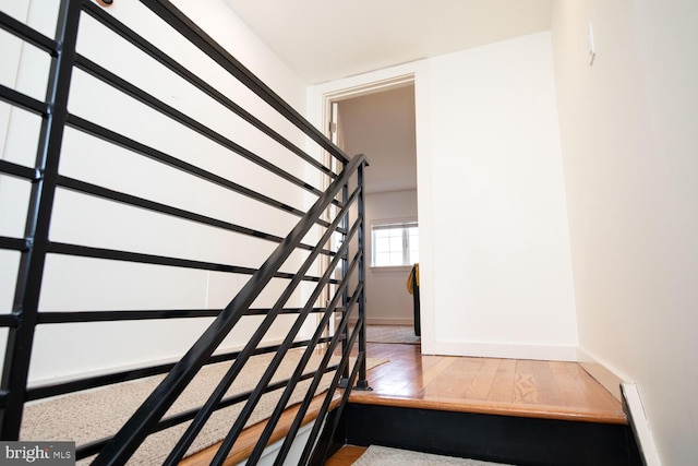 stairway featuring wood finished floors and baseboards