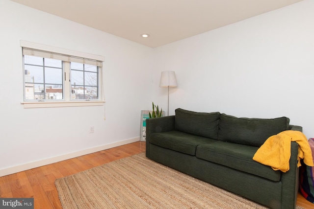 living room featuring baseboards, wood finished floors, and recessed lighting