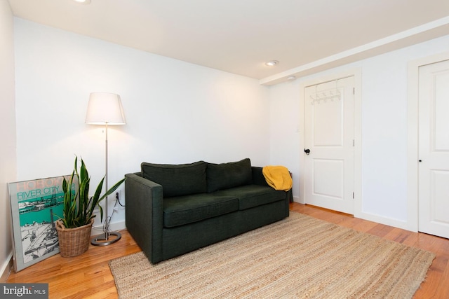 living area featuring baseboards, wood finished floors, and recessed lighting