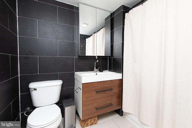 full bath featuring curtained shower, toilet, vanity, tile walls, and tile patterned floors