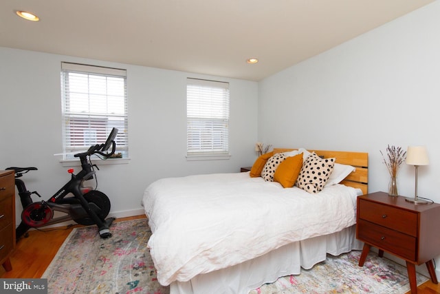 bedroom with baseboards, wood finished floors, and recessed lighting