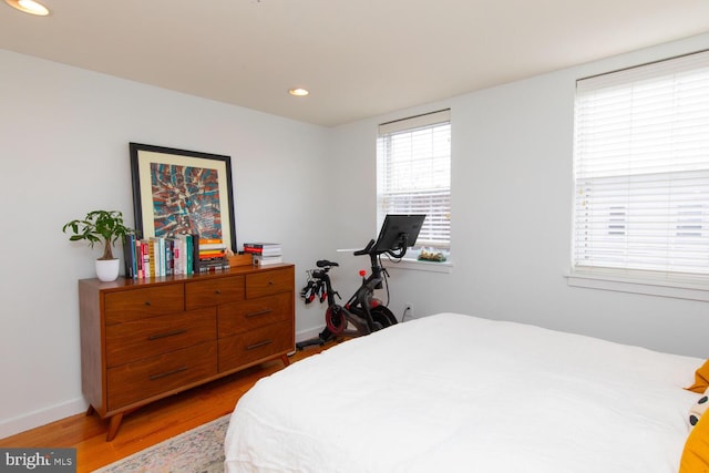 bedroom with baseboards, light wood-type flooring, and recessed lighting