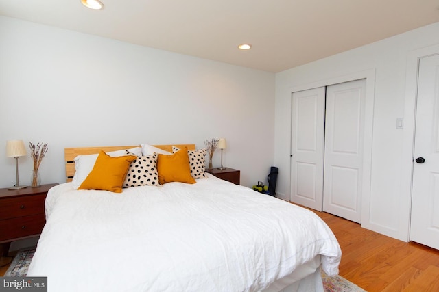 bedroom featuring a closet, recessed lighting, and light wood-style floors