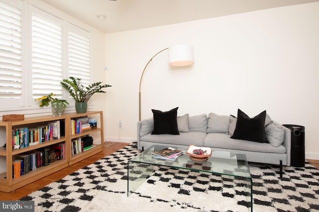 living area with baseboards and wood finished floors