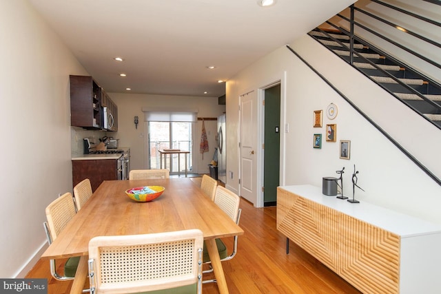 dining space featuring stairs, baseboards, light wood-style flooring, and recessed lighting