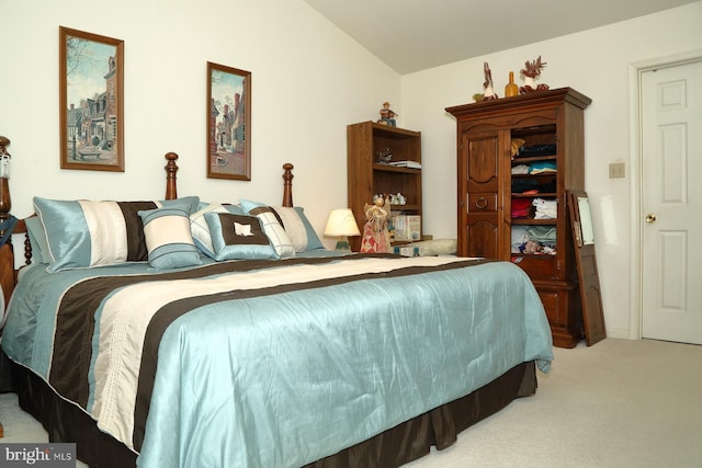 bedroom with vaulted ceiling and light colored carpet