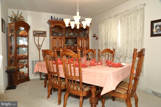 dining area with carpet, visible vents, and a notable chandelier