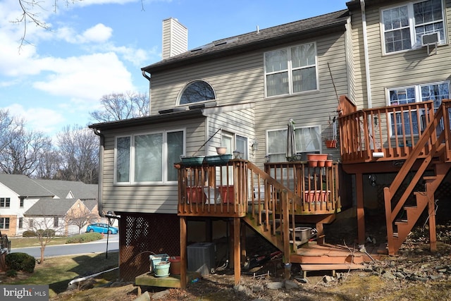 rear view of house featuring stairway, a deck, a chimney, and central air condition unit