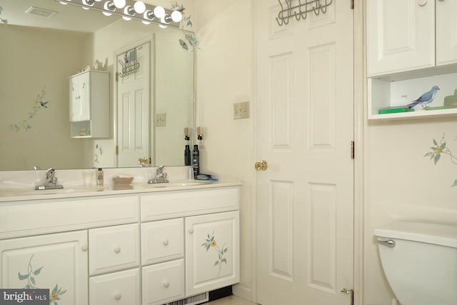 full bathroom featuring double vanity, a sink, visible vents, and toilet