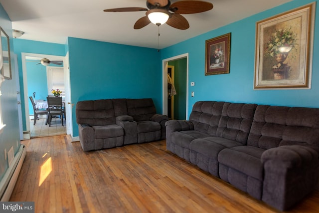 living room featuring ceiling fan, wood-type flooring, and baseboard heating