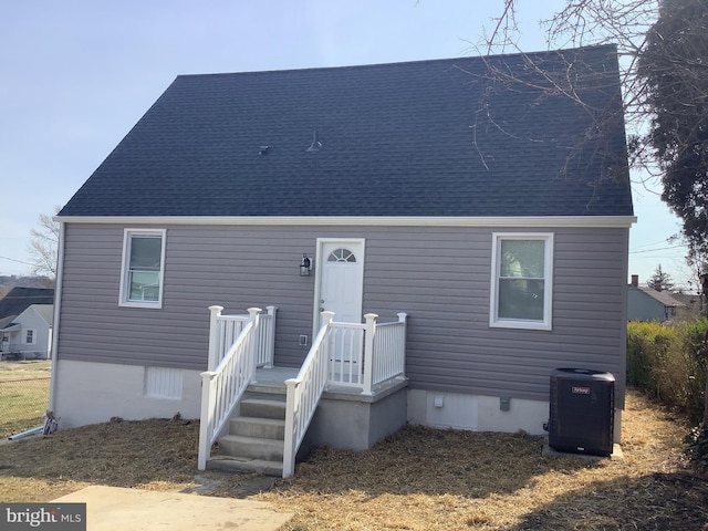 view of front of home featuring crawl space, central AC, and roof with shingles