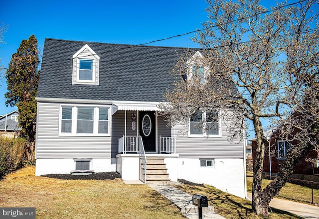 cape cod home with a front yard and a shingled roof