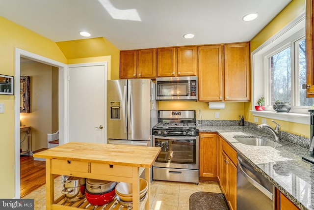 kitchen with brown cabinetry, wooden counters, recessed lighting, a sink, and appliances with stainless steel finishes