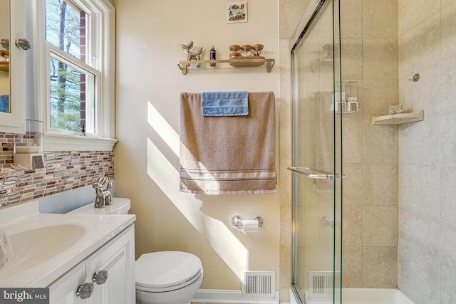 full bath with visible vents, a shower stall, toilet, decorative backsplash, and vanity