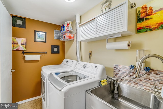 laundry room with a sink, baseboards, and washer and clothes dryer