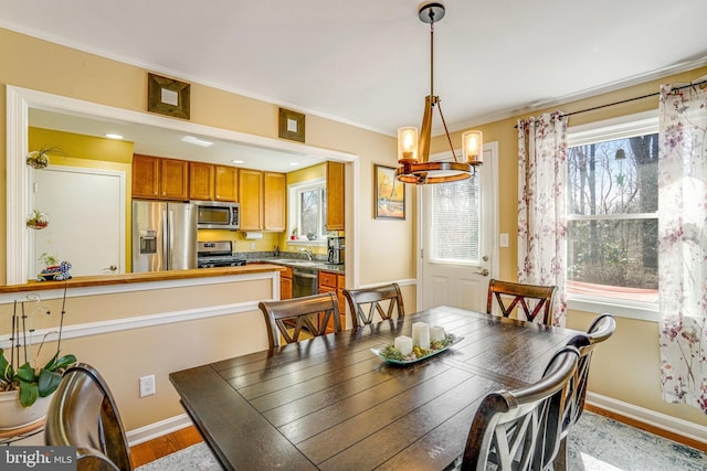 dining room with baseboards, an inviting chandelier, and wood finished floors