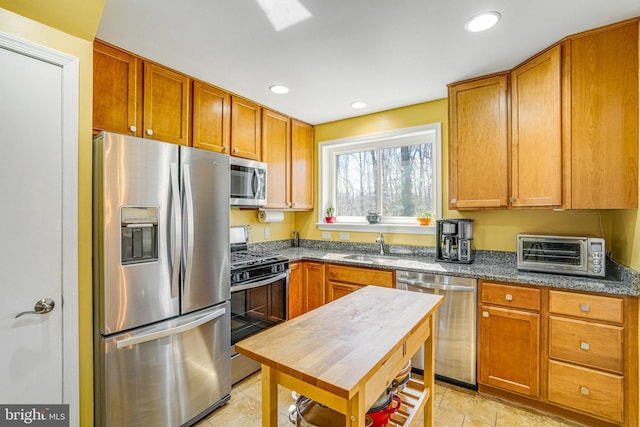 kitchen with brown cabinetry, a toaster, recessed lighting, and appliances with stainless steel finishes