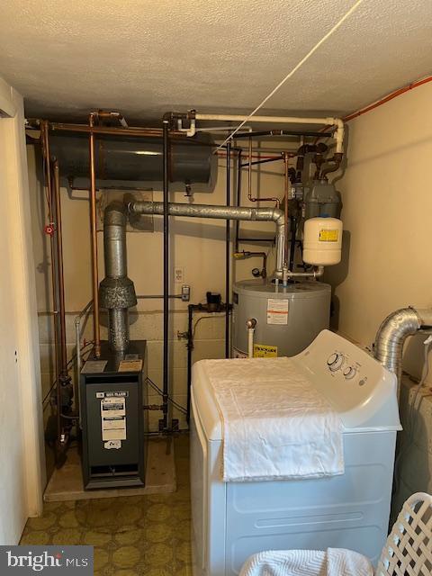 utility room featuring washer / dryer, a heating unit, and water heater