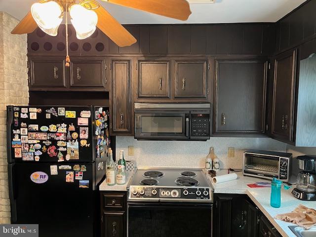 kitchen with a toaster, light countertops, ceiling fan, brick wall, and black appliances