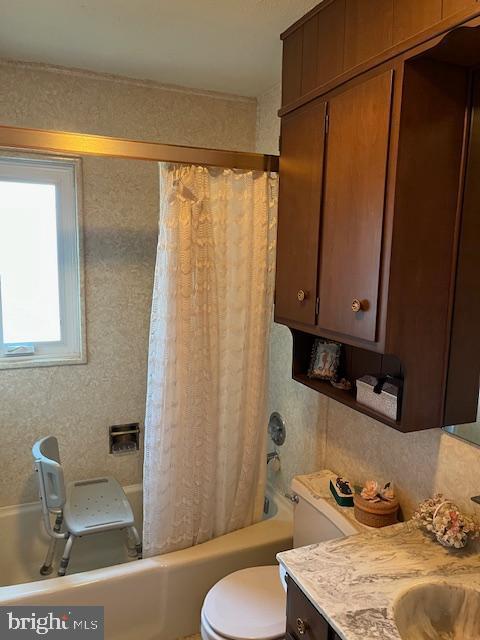 bathroom with vanity, toilet, and shower / bath combo with shower curtain