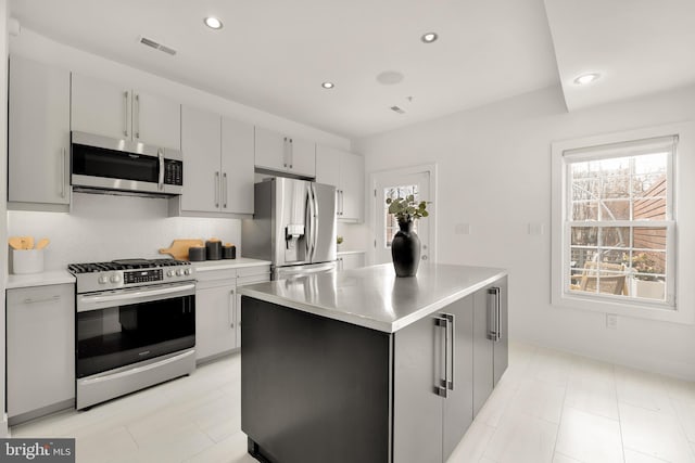 kitchen featuring tasteful backsplash, appliances with stainless steel finishes, visible vents, and a healthy amount of sunlight