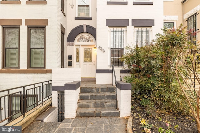 doorway to property with brick siding