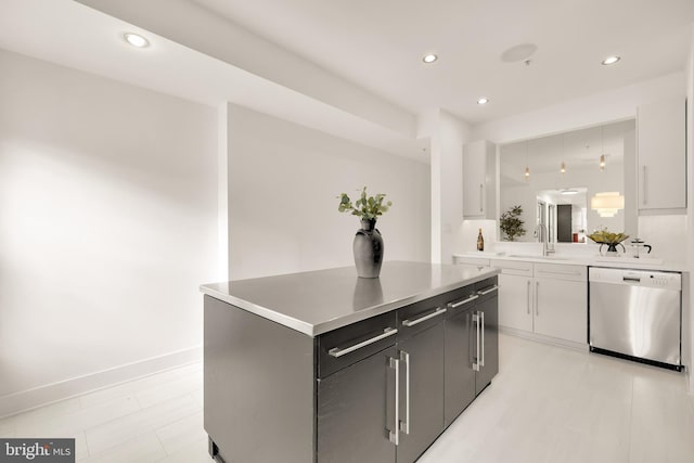 kitchen featuring a sink, light countertops, stainless steel dishwasher, and a center island